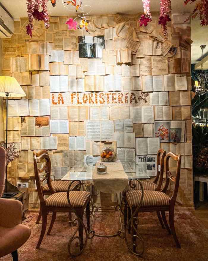 Pared de páginas de libro con el nombre La Floristería